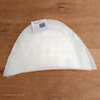 Witte vilten schoudervulling in halve‑maanvorm met productkaart op houten tafel &mdash; White felt half‑moon sho