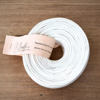 Witte pantalonband op rol, 5 cm breed, op lichte houten tafel &ndash; white trouser waistband roll, 5 cm wide, o