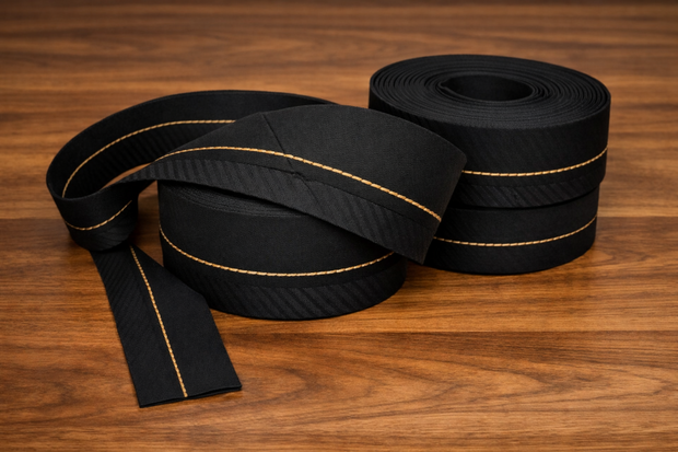 Zwarte pantalonband in bundel getoond &ndash; black trouser waistband displayed in a folded bundle