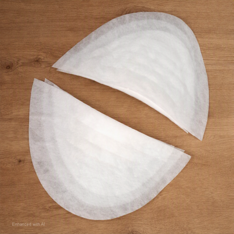 Twee witte vilten schoudervullingen in halve‑maanvorm op houten tafel &mdash; Two white felt half‑moon shoulder 